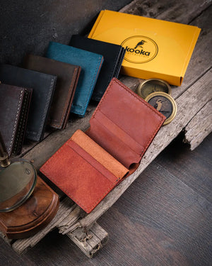 Rustik ahşap masa üzerinde açık halde Azur pueblo deri cüzdan iç yerleşimi ve kart bölmeleri, Kooka Leather