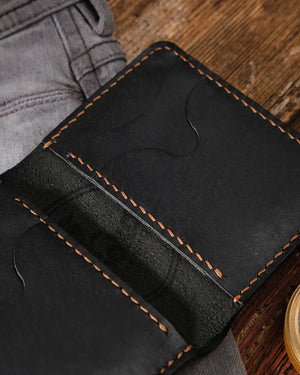 Siyah hakiki deri cüzdan iç tasarımı yakın çekim, parmak oyuntulu kart slotları ve kahverengi el dikişi detayı, Kooka Leather