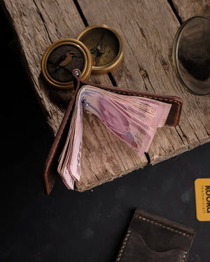 El dikişi deri para klipsli cüzdan, taba rengi Crazy Deri yüzeyiyle zengin doğal doku ve ton geçişleri sergileyerek katlanmış banknotları metal yay klipsiyle sıkıca tutuyor; Full Grain (Üst Tabaka) derinin karakteristik renk mottlingleri ve krem renkli saddle stitch el dikişi detayları ürüne özgün zanaatkar kimliği kazandırıyor. Kooka el yapımı deri cüzdan koleksiyonunun parçası olan bu model, taba tonunun sıcaklığını distressed deri patinasıyla buluşturuyor.