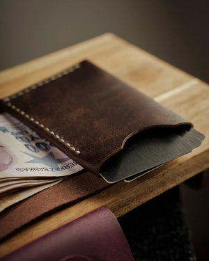 El dikişi deri cüzdan kahverengi Pueblo derisiyle işlenmiş, açık pozisyonda Türk lirası banknotları ve kart bölmeleri görünür halde; koyu kahve matta yüzey dokusu ve krem renkli el dikişi detayıyla öne çıkan kooka STYLE kompakt bifold model