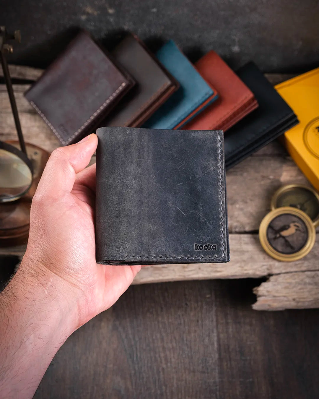 Elde tutulan kapalı gri Kooka Leather Azur cüzdan, avuç içine sığan kompakt boyutuyla crazy deri patina özelliğini yansıtıyor.