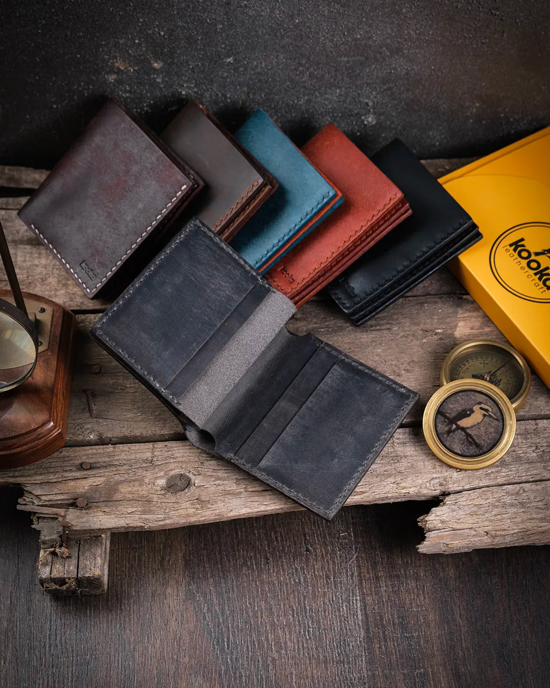 Kooka Leather Azur erkek deri cüzdanın açık haldeki kart slotları, gri crazy deri üzerine el dikişli saraç işçiliğiyle beton zemin üzerinde.
