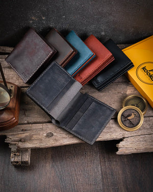 Kooka Leather Azur erkek deri cüzdanın açık haldeki kart slotları, gri crazy deri üzerine el dikişli saraç işçiliğiyle beton zemin üzerinde.