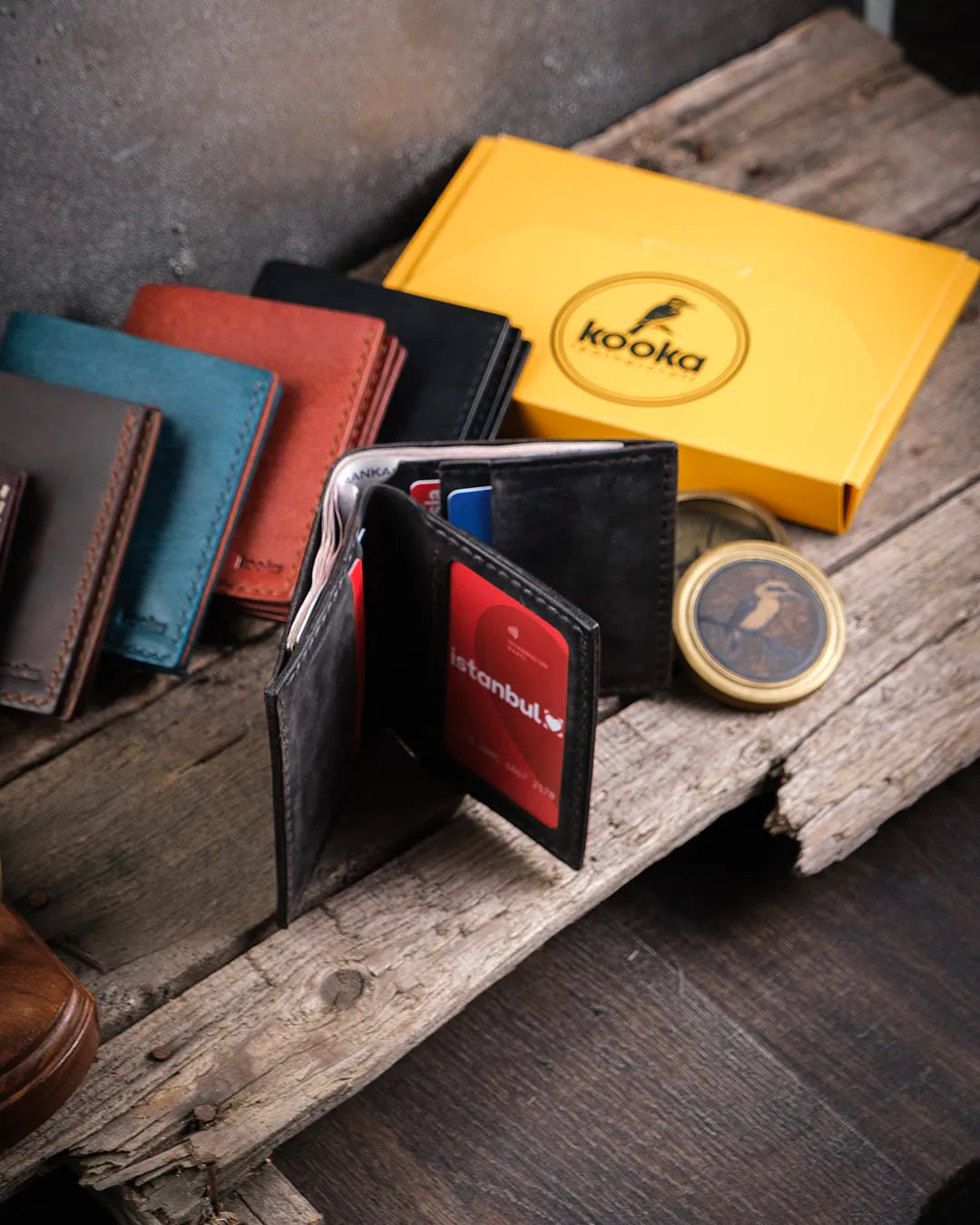 Dik duran açık Kooka Leather Azur bifold cüzdanın kitap gibi iki bölmeli iç yapısı ve sayfa şeklinde kart slotları, gri crazy deride sergileniyor.