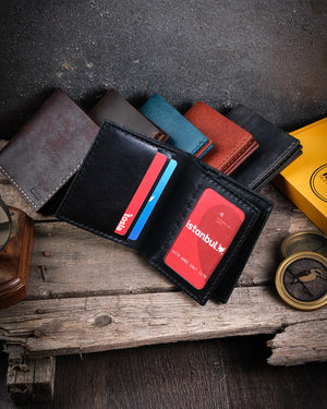 Siyah pueblo deri bifold cüzdan kart slotları dolu halde cepheden görünüm, şeffaf kimlik pencereli Kooka Leather Azur el yapımı tasarım