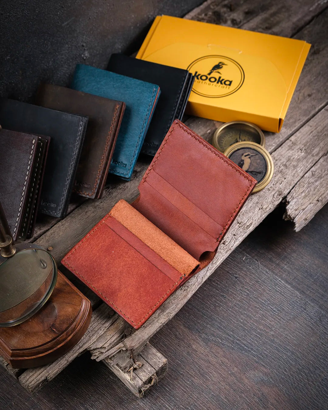 Rustik ahşap masa üzerinde açık halde Azur pueblo deri cüzdan iç yerleşimi ve kart bölmeleri, Kooka Leather