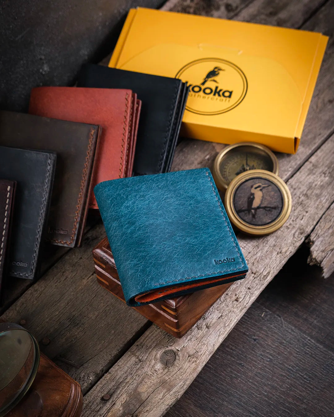 Ahşap masada vintage aksesuarlar arasında mavi turuncu pueblo deri Azur cüzdan kapalı köşeli tasarımı, Kooka Leather el yapımı