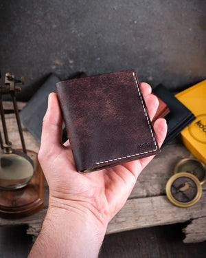 Avuç içine sığan kompakt boyutta kahverengi-olive Azur pueblo deri cüzdan, kapalı halde elde tutuş görünümü, Kooka Leather