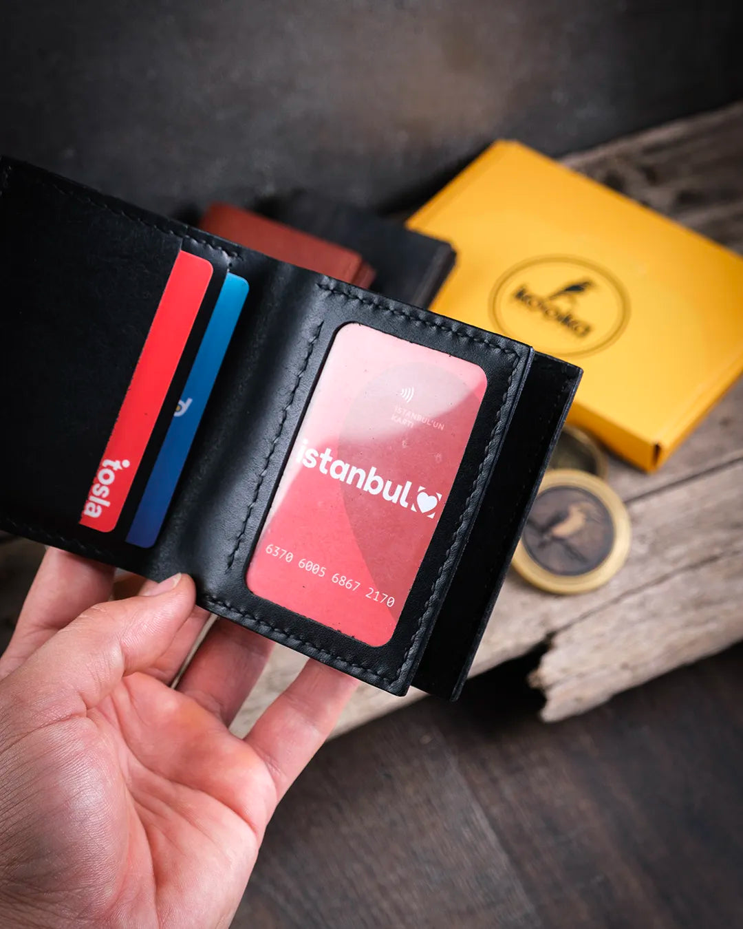 Soğuk doğal ışıkta kimlik bölmeli cüzdan şeffaf pvc pencere detayı yakın plan, Kooka Leather Azur saraç dikişi el işçiliği görünümü