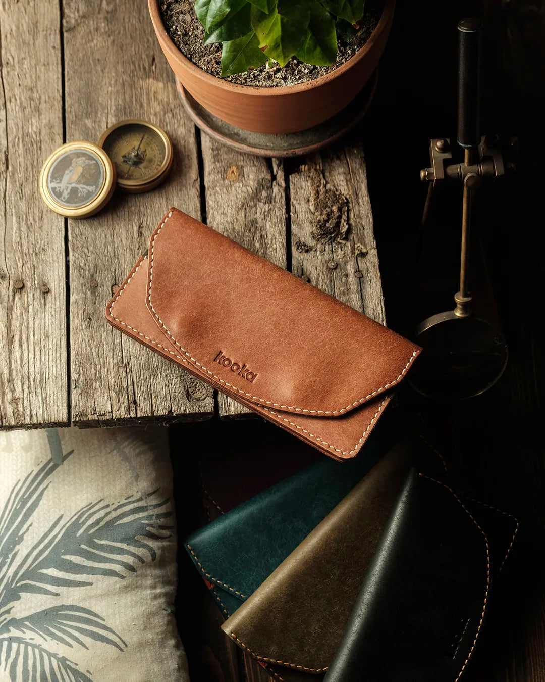 Hakiki deri kadın yatay cüzdan kapalı hali, taba PUEBLO deriden kavisli kapak, krem el dikişi ve kabartma kooka logosu; sıcak tonlu, mat ve karakterli dokusuyla Kooka Leather Tina üstten görünüm