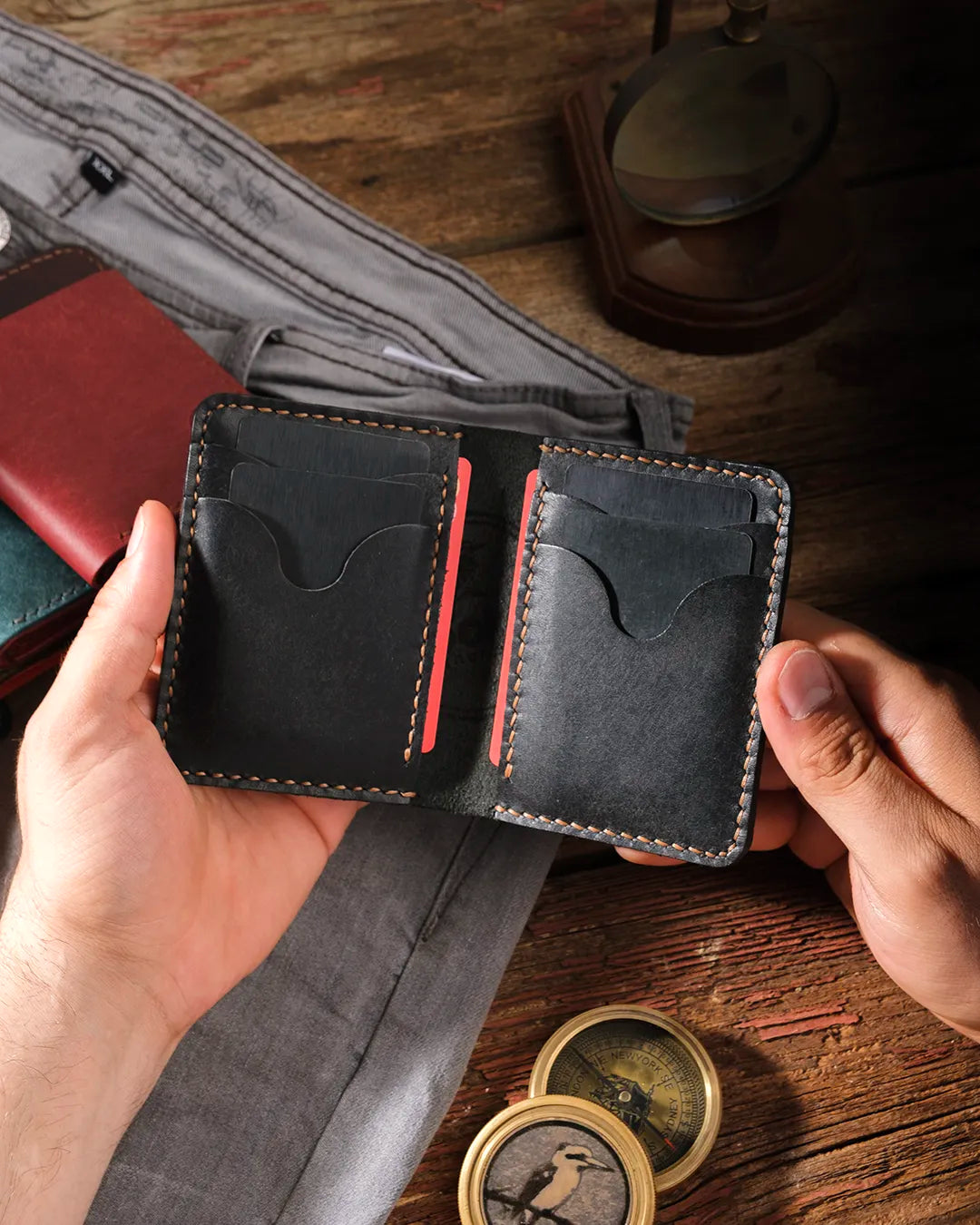 Çok kartlı pueblo deri erkek cüzdan elde açık, 6 kart slotunun tamamı dolu, siyah deri kahverengi dikiş uyumu, Kooka Leather