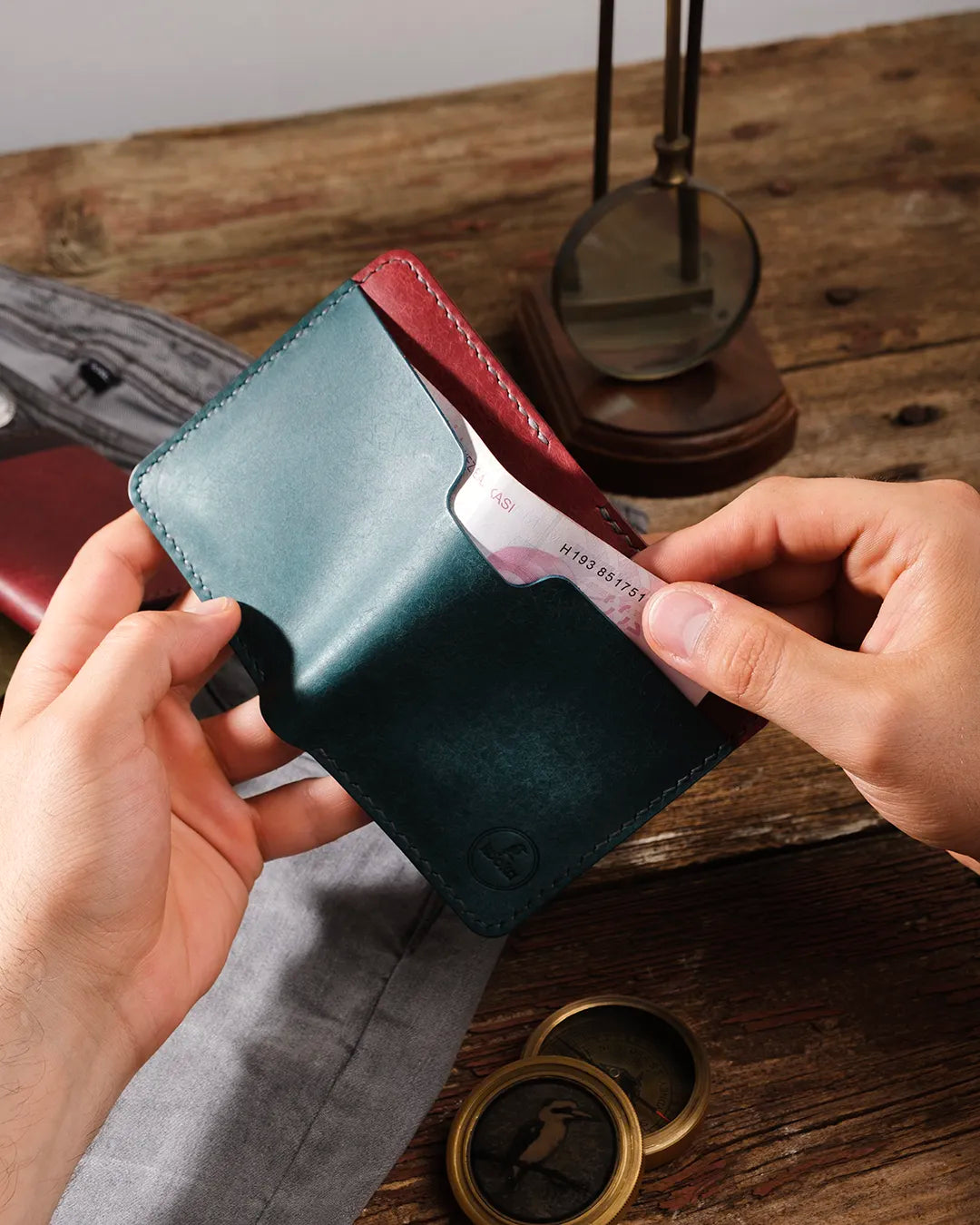 Elde tutulan açık pueblo deri cüzdanın dış kağıt para cebinden 200 TL banknot çıkartılıyor, dikey bifold tasarımla Kooka Leather el yapımı cüzdan