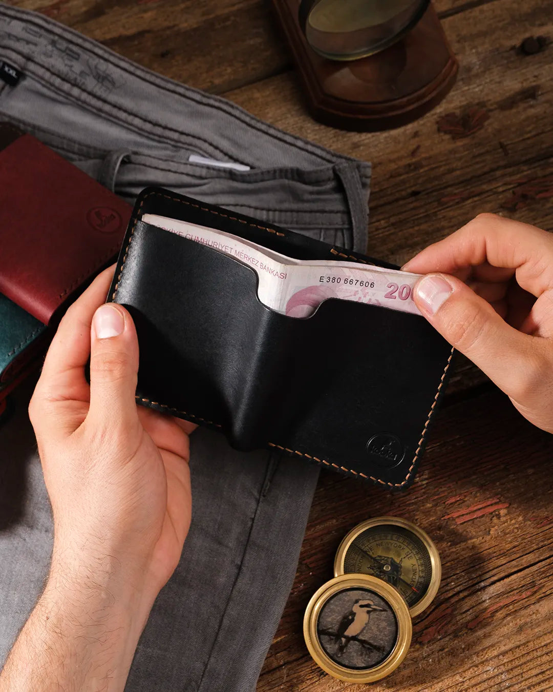 El yapımı siyah pueblo deri cüzdan elde tutuluyor, dış arka para cebinden 200 liralık banknot çıkarılma anı, Kooka Leather