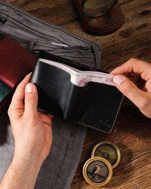 El yapımı siyah pueblo deri cüzdan elde tutuluyor, dış arka para cebinden 200 liralık banknot çıkarılma anı, Kooka Leather