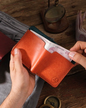 Pueblo deri minimalist erkek cüzdan elde tutuluyor, kağıt para cebinden banknot alınırken çekilmiş kullanım fotoğrafı, Kooka Leather