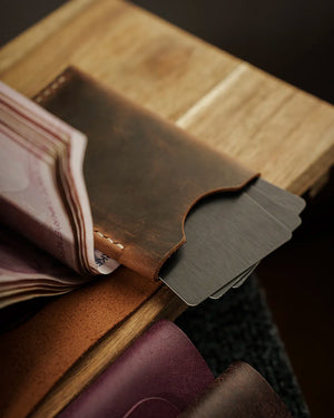 Full Grain (Üst Tabaka) Crazy Deri cüzdan detayı — koyu tütün kahvesi tonlu STYLE - DIKEY DERI CUZDAN - KOOKA LEATHER modelinin angled kart bölmesi flabından dışarı taşan kartlar ve el dikişi işçiliği ile nakit bölmesinden açılan banknot katmanları, yüzeyin doğal pull-up renk geçişleri ve mat dokulu distressed görünümü ön planda.