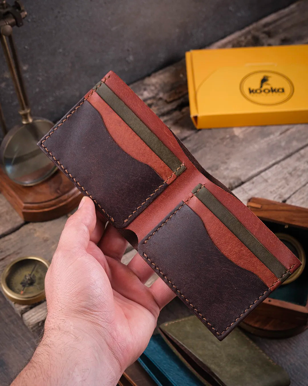 Rustik atmosferde tek elle açık tutulan Kooka Leather Torn bifold pueblo deri cüzdan, rahat kullanım görünümü