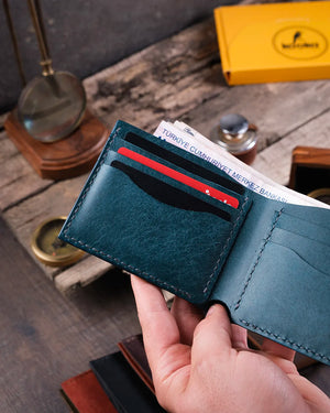 Gündelik ortamda elde tutulan mavi bifold pueblo deri cüzdan, açık halde kart slotları ve para bölmesi detaylarıyla görünüyor, Kooka Leather