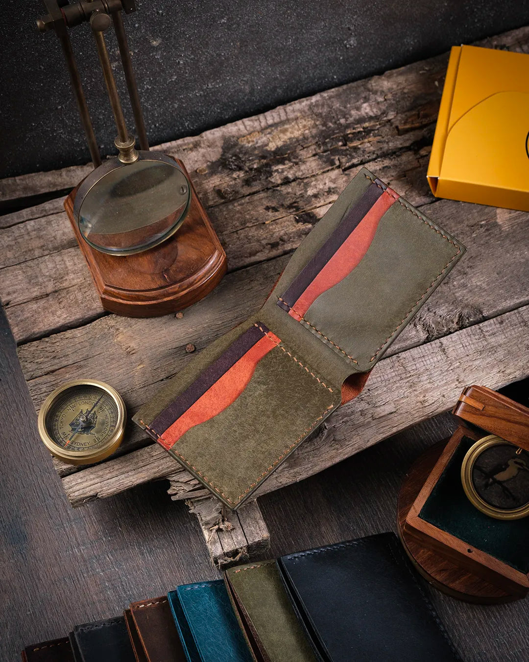 Ahşap zemin üzerinde taba pueblo deri Kooka Leather Torn bifold cüzdan açık halde, iç kart slotları ve bölmeleri görünümü