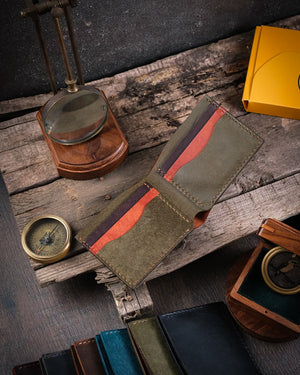 Ahşap zemin üzerinde taba pueblo deri Kooka Leather Torn bifold cüzdan açık halde, iç kart slotları ve bölmeleri görünümü