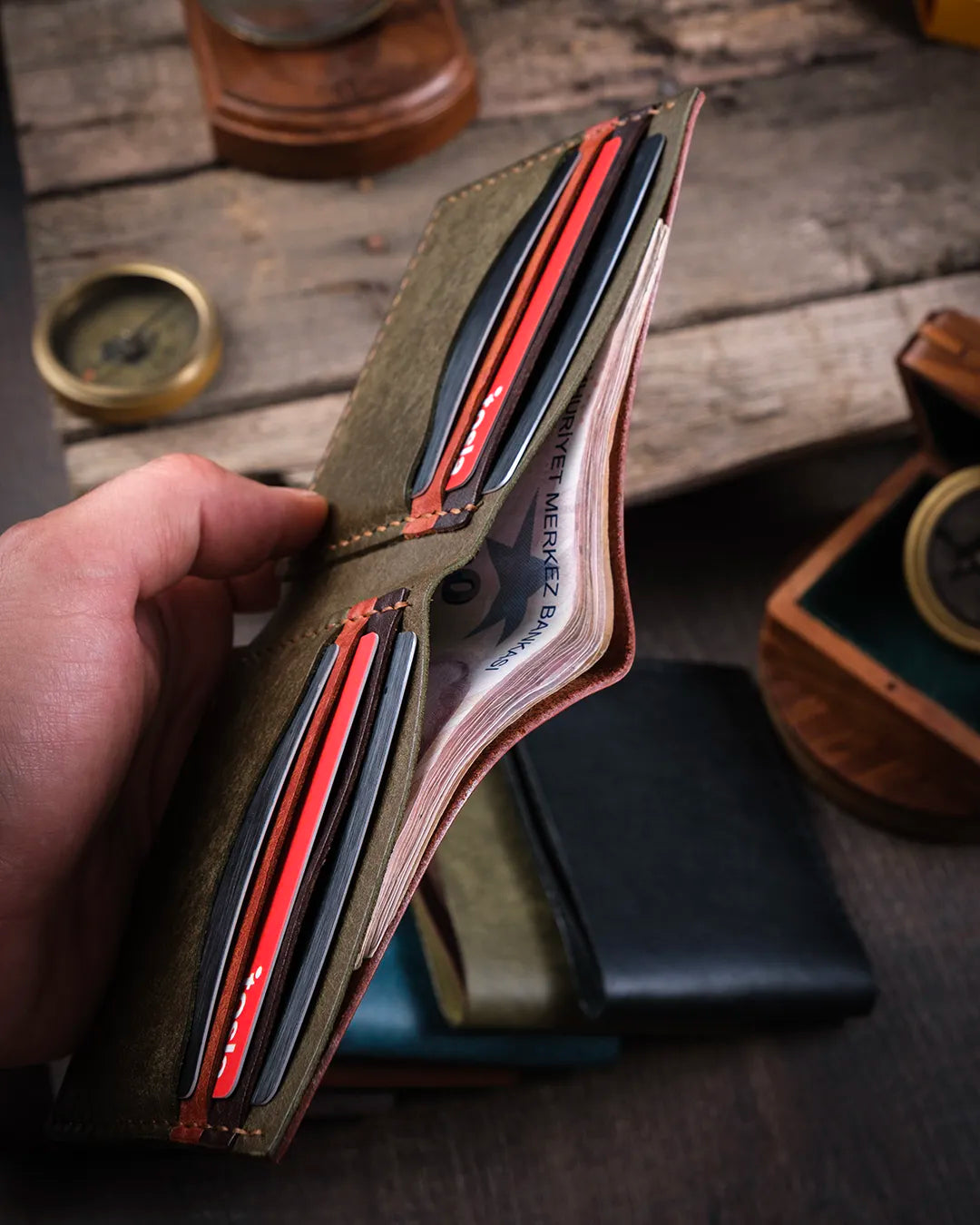Elde tutulan açık halde pueblo deri bifold cüzdan, geniş kağıt para bölmesi ve iç kapasitesi rustik ışıkta, Kooka Leather