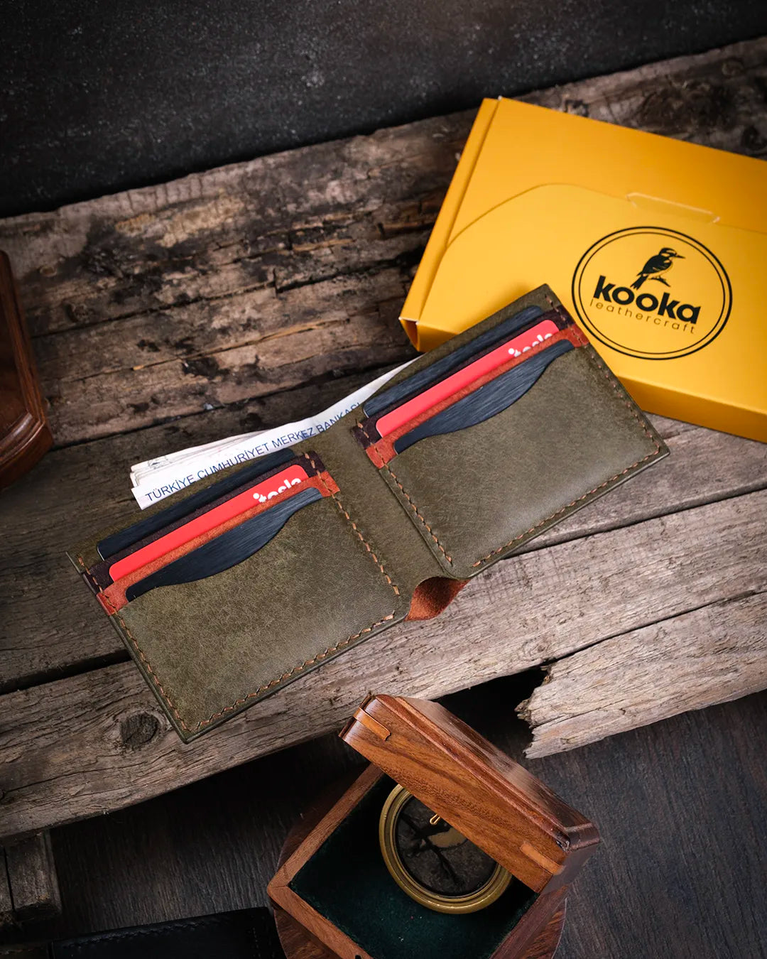 Üstten açık halde pueblo deri erkek cüzdan, kart ve para bölmeleri dolu görünüm, Kooka Leather el dikişi bifold tasarım ahşapta