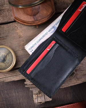Rustik ahşap üzerinde kart slotları yerleşiminin yakın çekimde göründüğü siyah el yapımı hakiki deri cüzdan, Kooka Leather